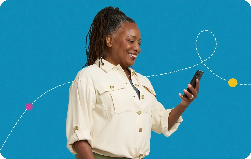 A woman with long dark hair in a light button-up shirt smiles while looking at her smartphone. The background is blue with a playful dotted line and colored dots.